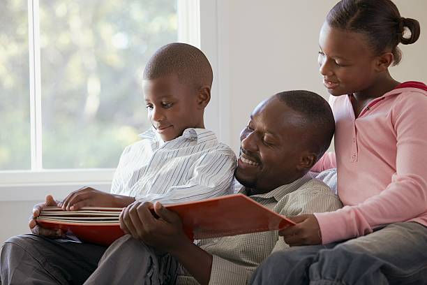 istock Father reading a storybook with his children 520424028