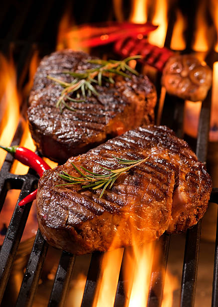 Beef steaks on the grill Beef steaks on the grill with flames steak vertical beef meat stock pictures, royalty-free photos & images