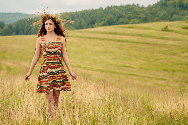 Woman walking in field. Russia. Teploozersk village