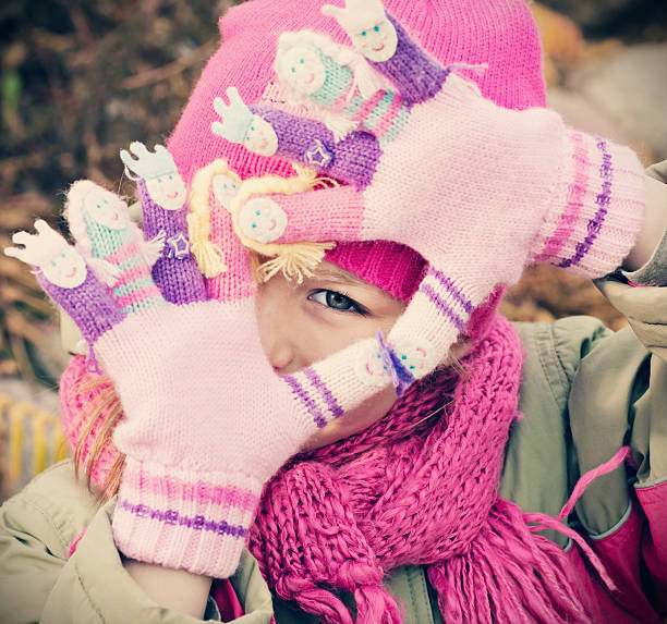 istock Little Girl Playing Outdoors in Winter Clothing 520437613