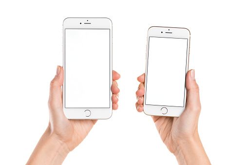 Koszalin, Poland - October 26, 2014: Close-up shot of iPhone 6 and iPhone 6 Plus hand-held by woman. iPhone 6 (4.7 inches) and 6 Plus (5.5 inches) are next generation smartphone from Apple. Devices displaying blank screen - white picture.