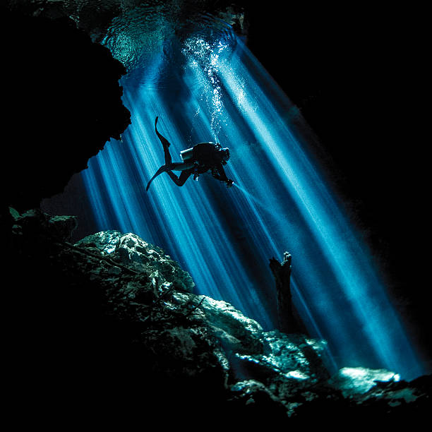 Rays of light uderwater Scuba diver exploring the underwater cenotes in Mexico near Puerto Aventuras. Caves are dark and the light always gives different amazing ambient underwater. puerto aventuras stock pictures, royalty-free photos & images