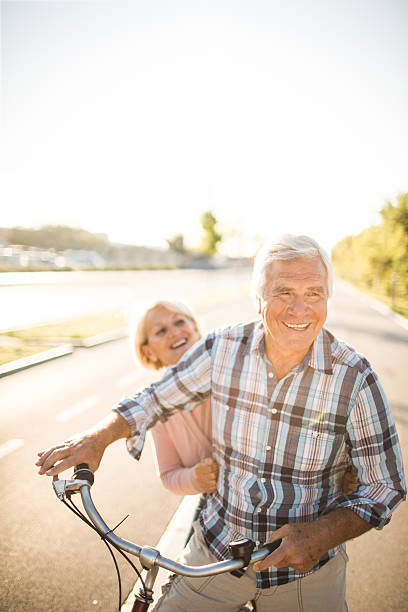 amoroso seniors - action mature adult bicycle senior couple imagens e fotografias de stock