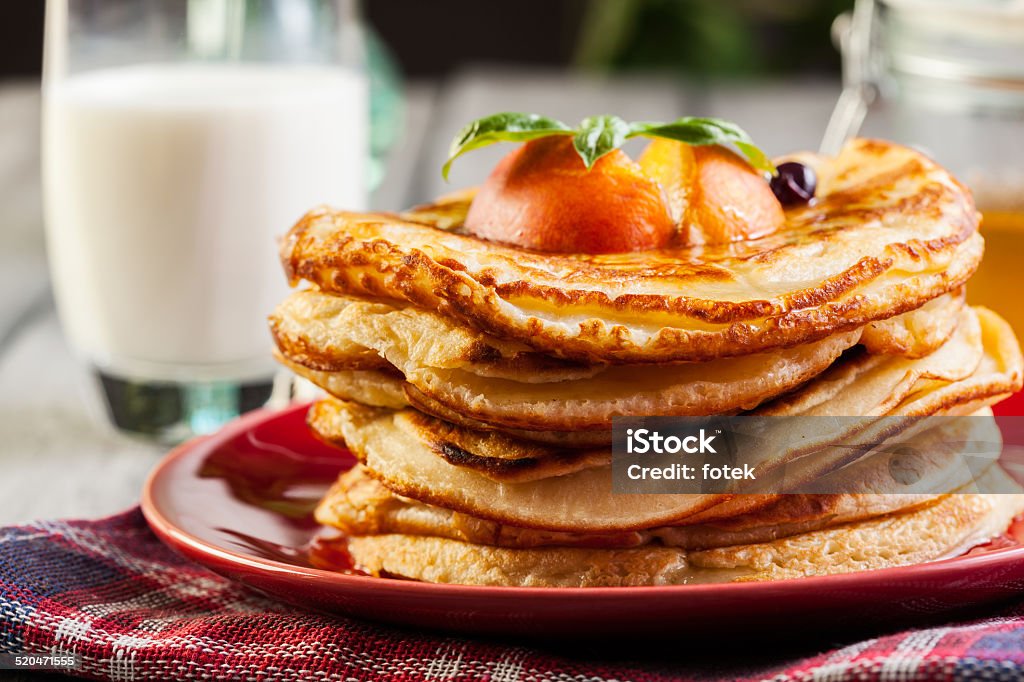 Panqueques con la miel, frutas y vaso de leche - Foto de stock de Alimento libre de derechos