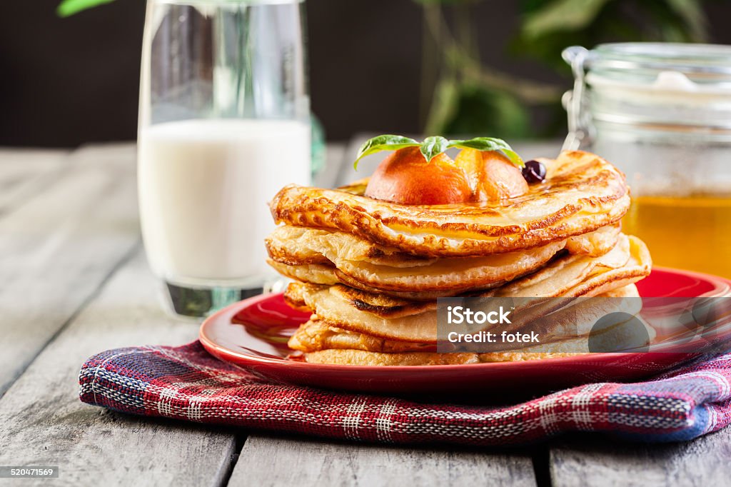 Panqueques con la miel, frutas y vaso de leche - Foto de stock de Alimento libre de derechos