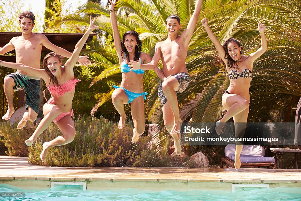 Grupo de adolescente amigos salto en piscina - Foto de stock de Piscina libre de derechos