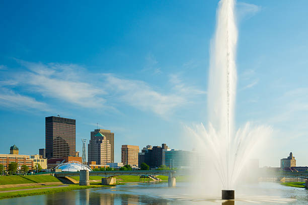 Dayton skyline and water fountain Dayton downtown skyline with a water fountain on the Great Miami River in the foreground. dayton ohio skyline stock pictures, royalty-free photos & images