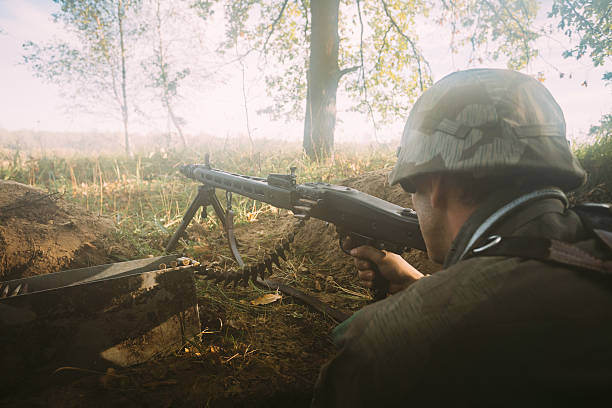 istock Re-enactor dressed as german wehrmacht soldier aiming a machine 520489734