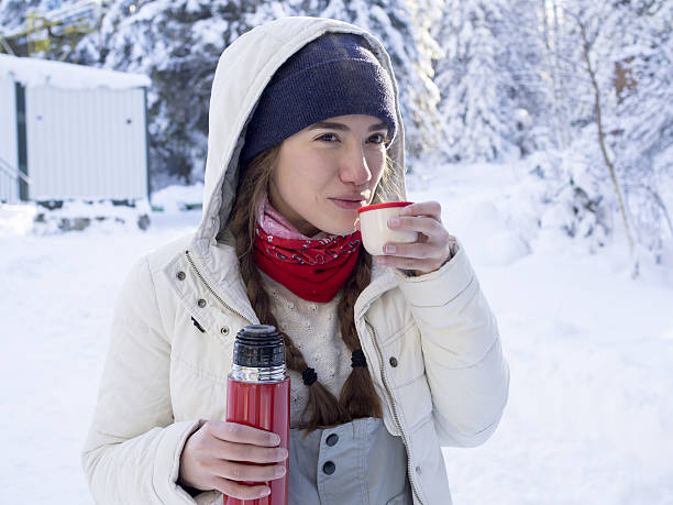 istock Girl drinking tea from a thermos on a winter mountain. 520489966