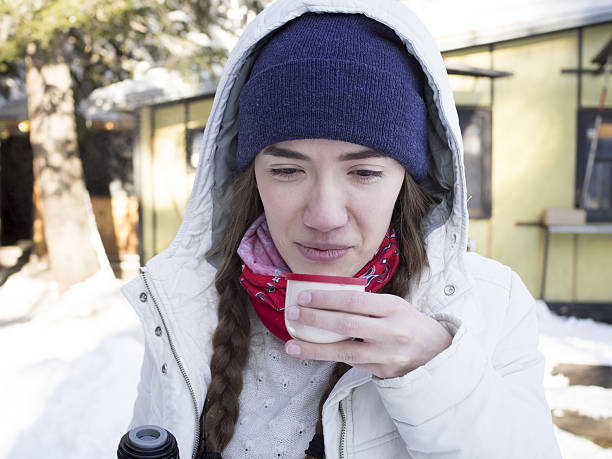 istock Girl drinking tea from a thermos on a winter mountain. 520490442