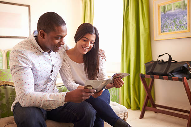 Young couple read a guide brochure together in a hotel room