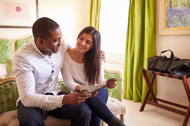istock Young couple study a guide brochure together in a hotel room 520492332