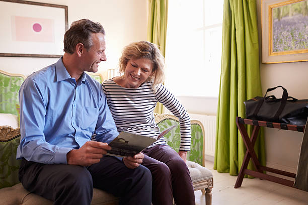 istock Senior couple study a guide brochure together in hotel room 520492456