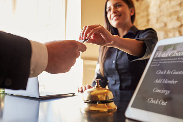 Guest takes room key card at check-in desk of hotel Guest takes room key card at check-in desk of hotel, close up concierge service stock pictures, royalty-free photos & images