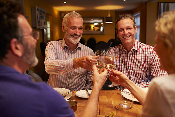 istock Four friends making a toast during a meal at a restaurant 520493012