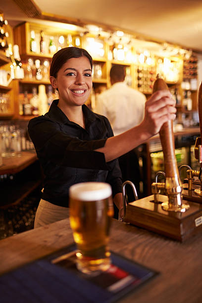 istock A young woman working behind a bar looking to camera 520493240