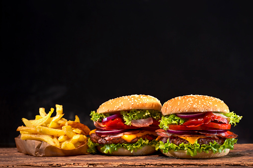 Delicious hamburger with french fries on wooden table