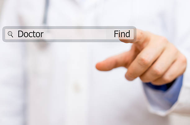 doctor pressing find doctor  on virtual search bar. stock photo