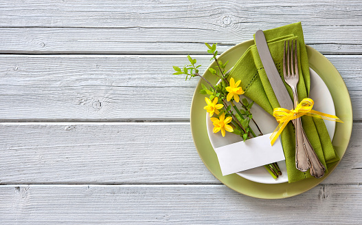 Spring table place setting with daffodils. Holidays background