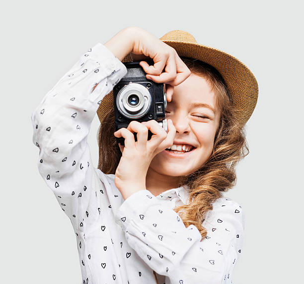Young photographer looking at camera Funny little girl looking at camera photographing photos stock pictures, royalty-free photos & images