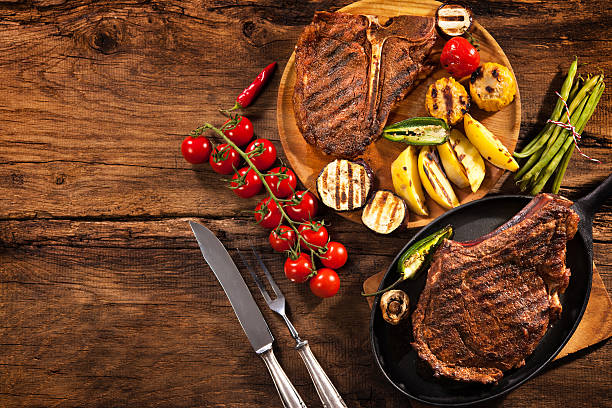 istock Beef steaks with grilled vegetables on wood 520499974