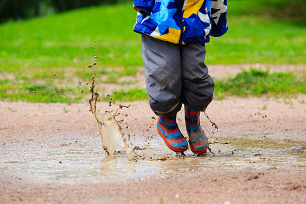 istock child playing in muddy puddle 520500226