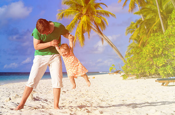 istock father and little daughter play at beach 520500904