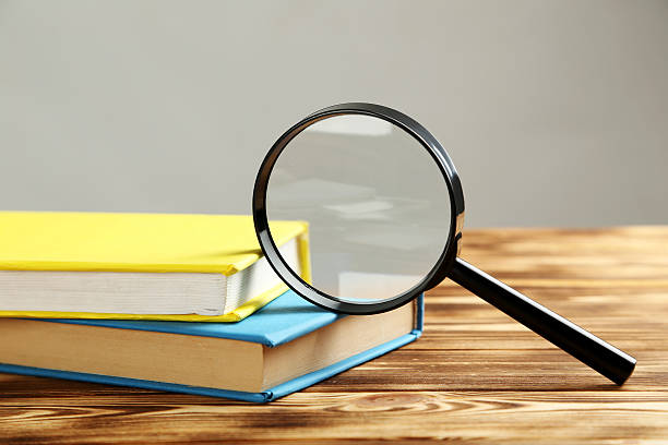 istock Magnifying glass on a brown wooden table 520501126