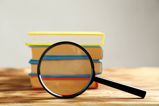 istock Magnifying glass on a brown wooden table 520501164