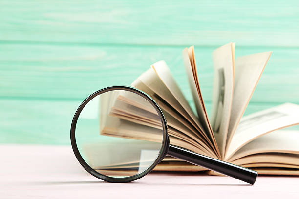 istock Magnifying glass on a pink wooden table 520501218