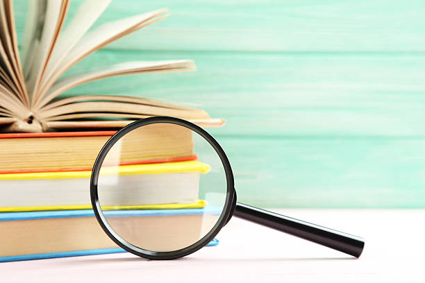 istock Magnifying glass on a pink wooden table 520501264