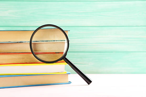 istock Magnifying glass on a pink wooden table 520501308
