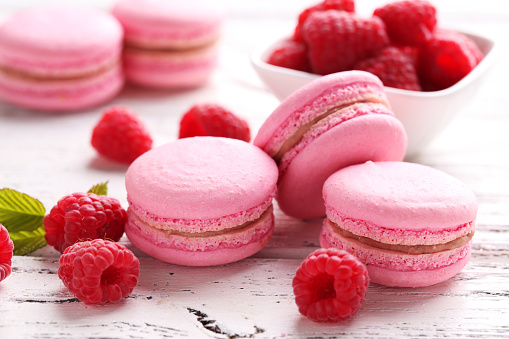 Raspberry macarons on white wooden background