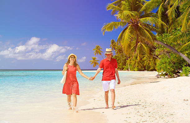 istock happy loving couple walking on beach 520504724
