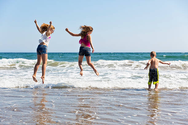 istock Brother and Sisters Play in the Surf 520506469