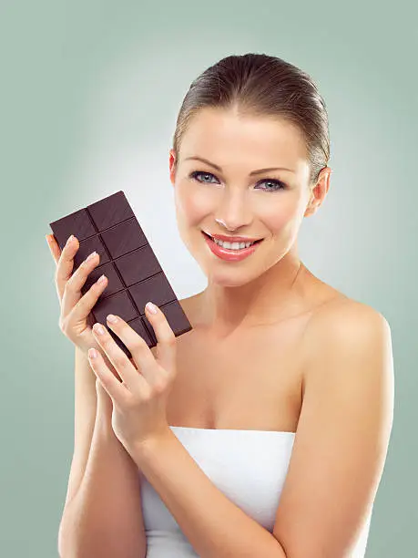 Studio portrait of a beautiful young woman holding a slab of dark chocolatehttp://azarubaika.com/iStockphoto/2014_05_09_Victoria_Beauty.jpg