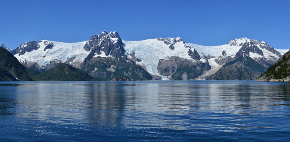 Wiew of the Alaskan tidal glaciers at Kenai Fjords National Park, Kenai Peninsula, Alaska. These glaciers are retreating, proving global warming. Picture taken on unusually sunny day from a cruise boat entering fjords from Seward, at location: N 59o47.115’ W 150o03.064’