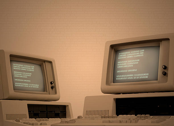 Vintage computer technology background with binary code Vintage technology beige background with two old computers showing binary code on its monitor. Code spreads across image area. Retro revival of seventies devices. Plenty of copy space on the side. Low-key background for easy costumization. coming out of computer screen stock pictures, royalty-free photos & images