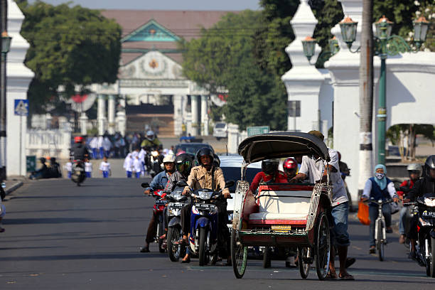 Indonesia: Traffic in Yogyakarta Yogyakarta, Indonesia - August 13, 2014: Varioius forms of transportation all together at a traffic stop in central Yogyakarta. yogyakarta stock pictures, royalty-free photos & images