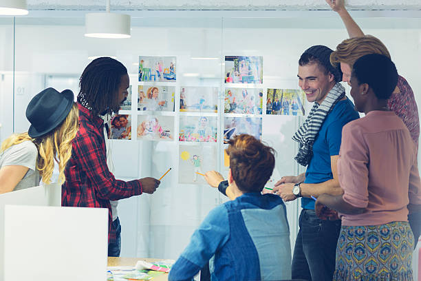 istock Multi-ethnic Creative Young Designers Team standing and looking at images. 520512033