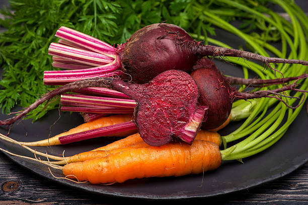 istock Beets and carrots with leaves closeup 520535437