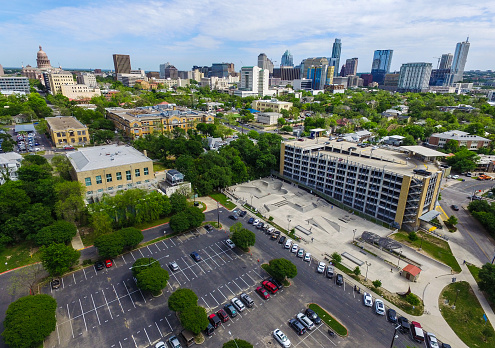 Austin Texas Aerial Shot Over House Skatepark near ACC Campus and the Texas State Capitol Building stands high on a hilltop with the Skyline Cityscape of the Austin Downtown area 