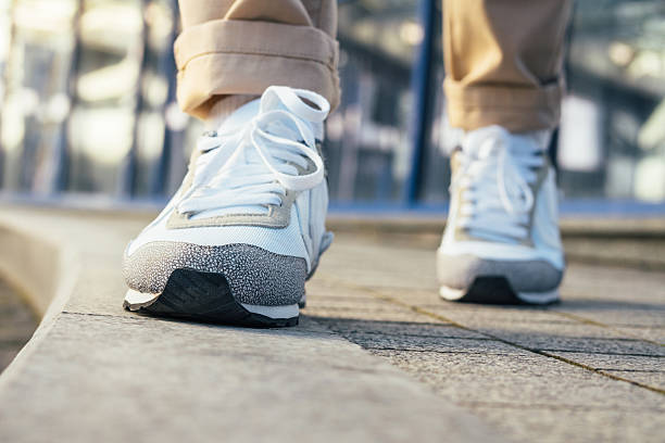 istock Legs in beige pants and white sneakers 520544844