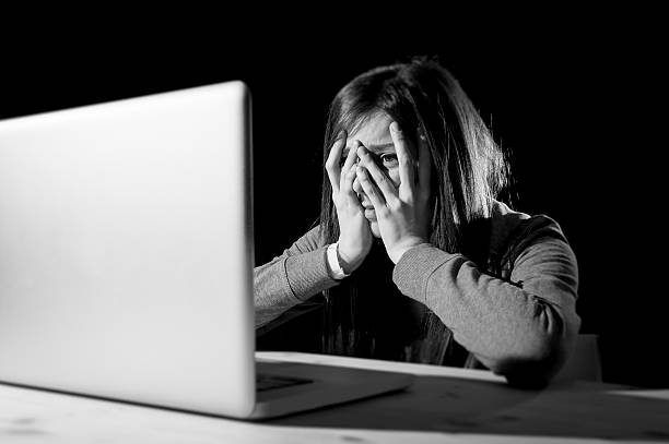 teenager girl suffering internet cyber bullying scared and depressed cyberbullying stock photo