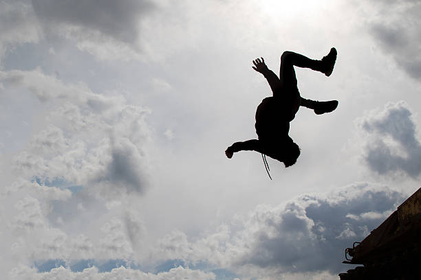 istock Teenage boy doing a back flip silhouetted 520548114