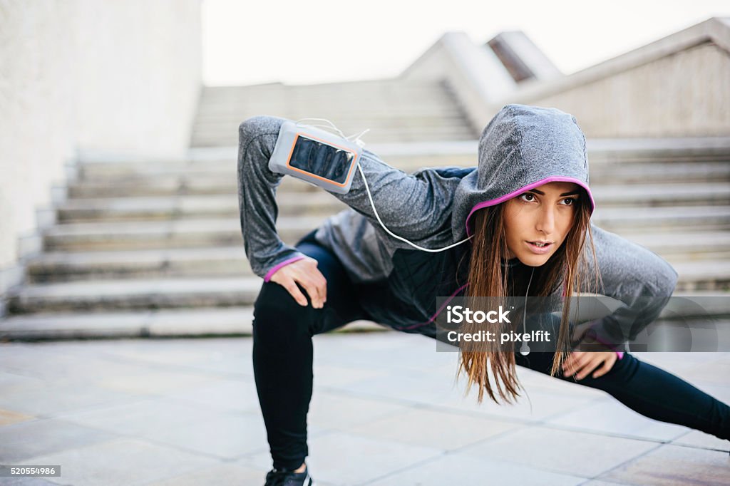 Sport in the city Young woman in sports wear exercising in the morning outdoors at urban scene, with copy space Stretching Stock Photo