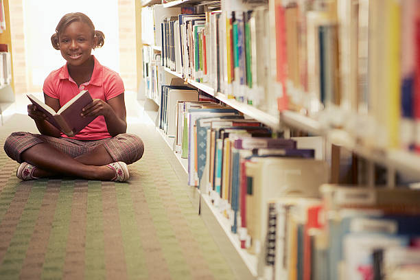 istock Girl reading at the library 520555410