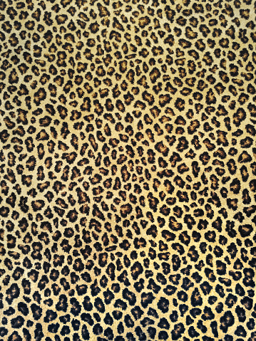 Classic black and yellow leopard fabric background.