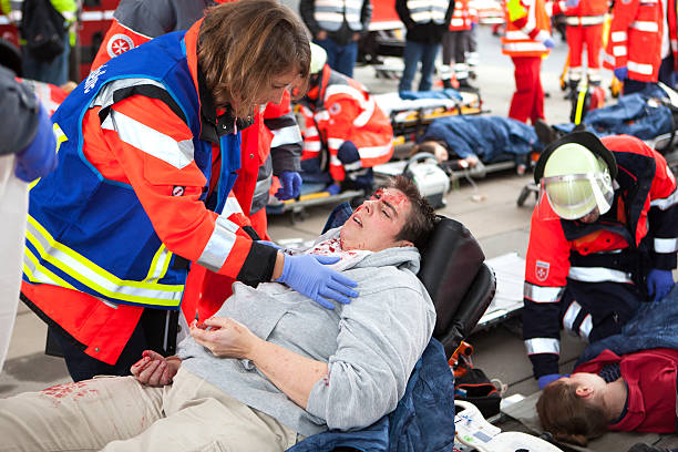 Mass Casualty Drill - Triage Wiesbaden, Germany - October 25, 2014: Large mass casualty drill with rescue services and emergency doctors in the city center of Wiesbaden. Paramedics and firefighters are taking care of injured persons - an emergency doctor is triaging a severely injured female victim. The displayed injuries and victims are NOT real, approximately 30 actors portrayed wounded or injured people which have been made up by a special team of makeup artists triage stock pictures, royalty-free photos & images