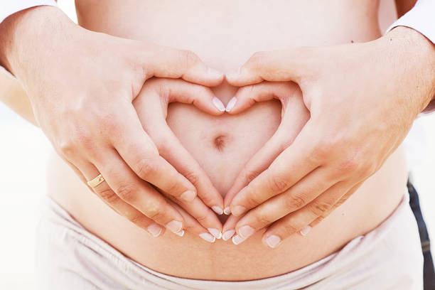 istock Couple making a heart shape on the pregnant belly 520565417